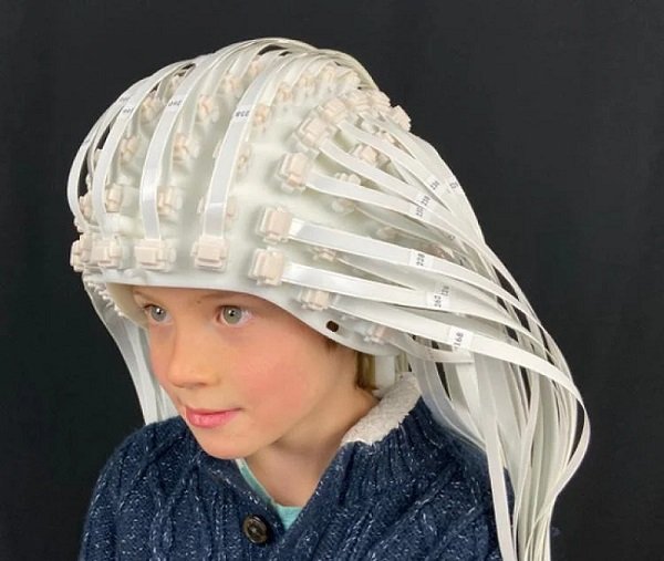 A child wears a helmet manufactured by FieldLine Inc. made up of more than 100 optically pumped magnetometer (OPM) sensors. Courtesy of FieldLine Inc.