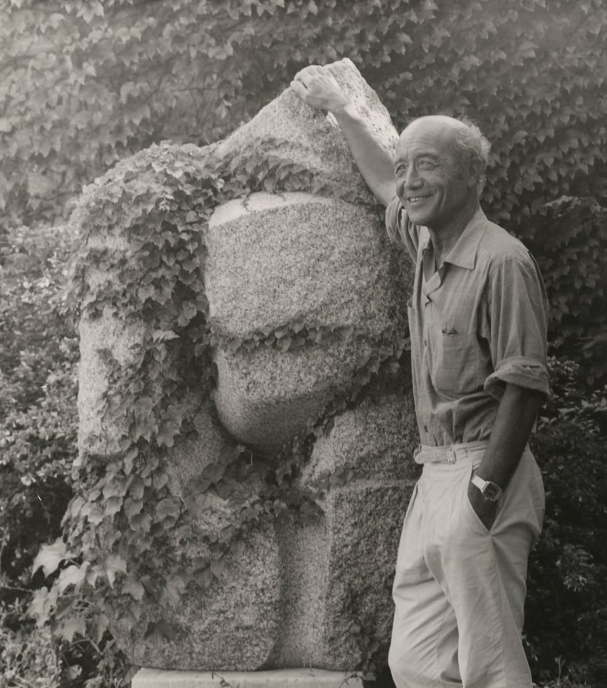 Isamu Noguchi in front of a stone